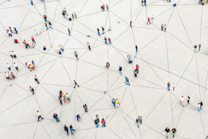 The image shows people from above, standing alone or in small groups forming a network, visualizes by black lines.